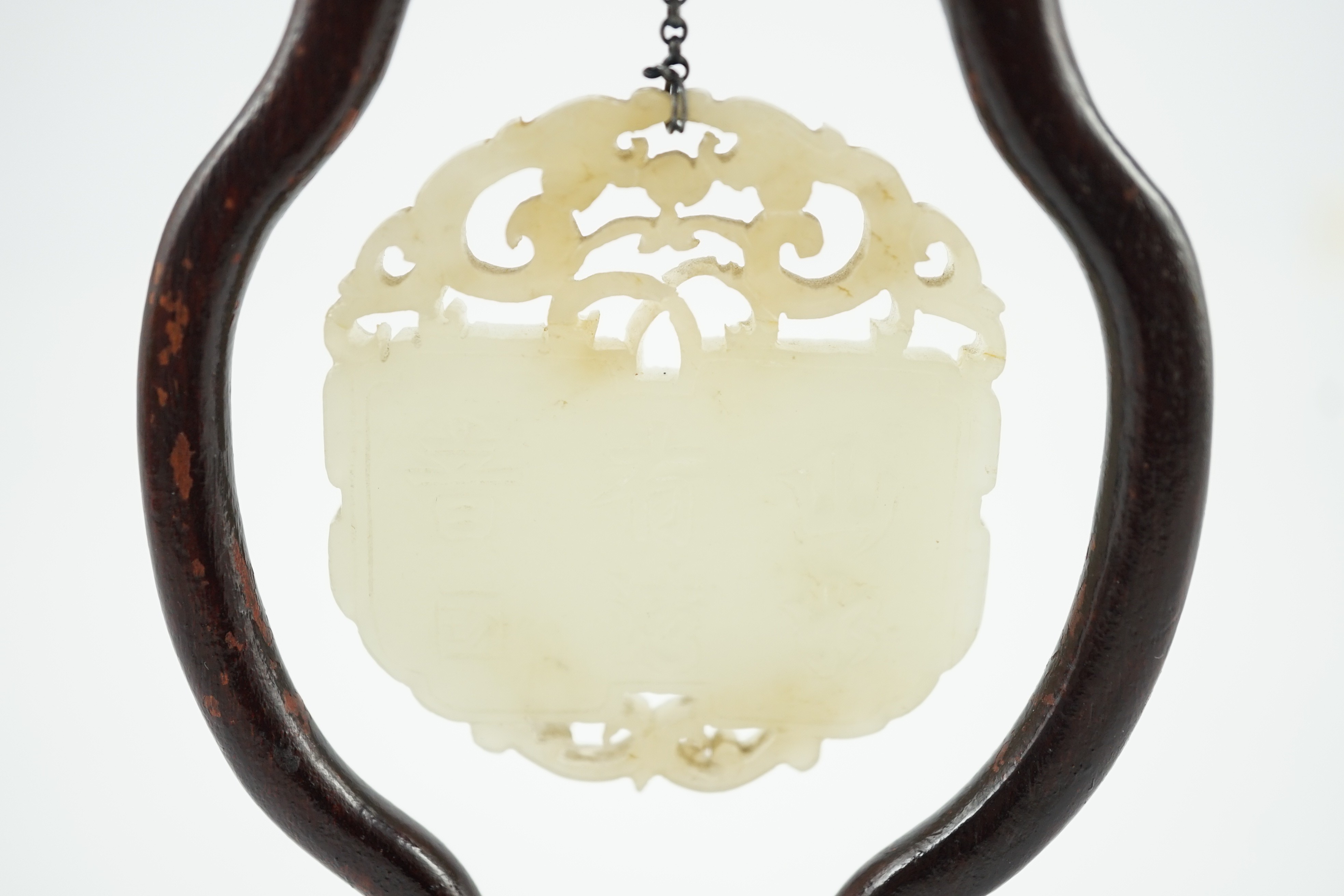 A Chinese pale celadon jade inscribed plaque, 19th/20th century, 5.1cm, suspended from a wood stand